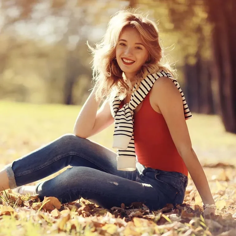 A young woman relaxing outdoors in autumn leaves